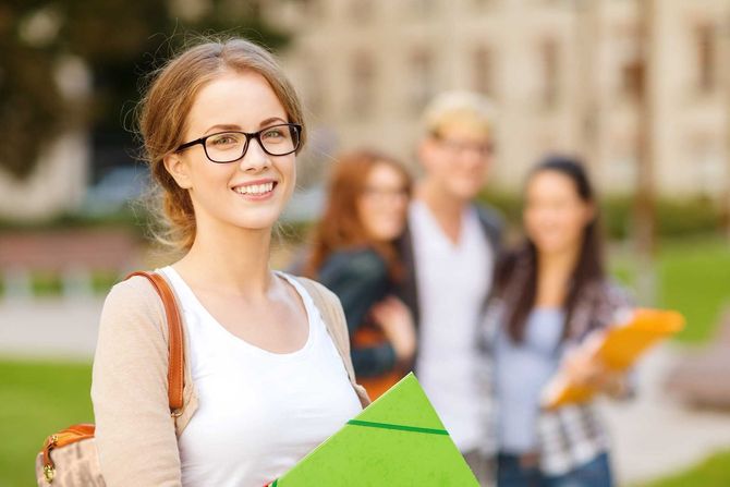 female student in eyglasses with folders 
