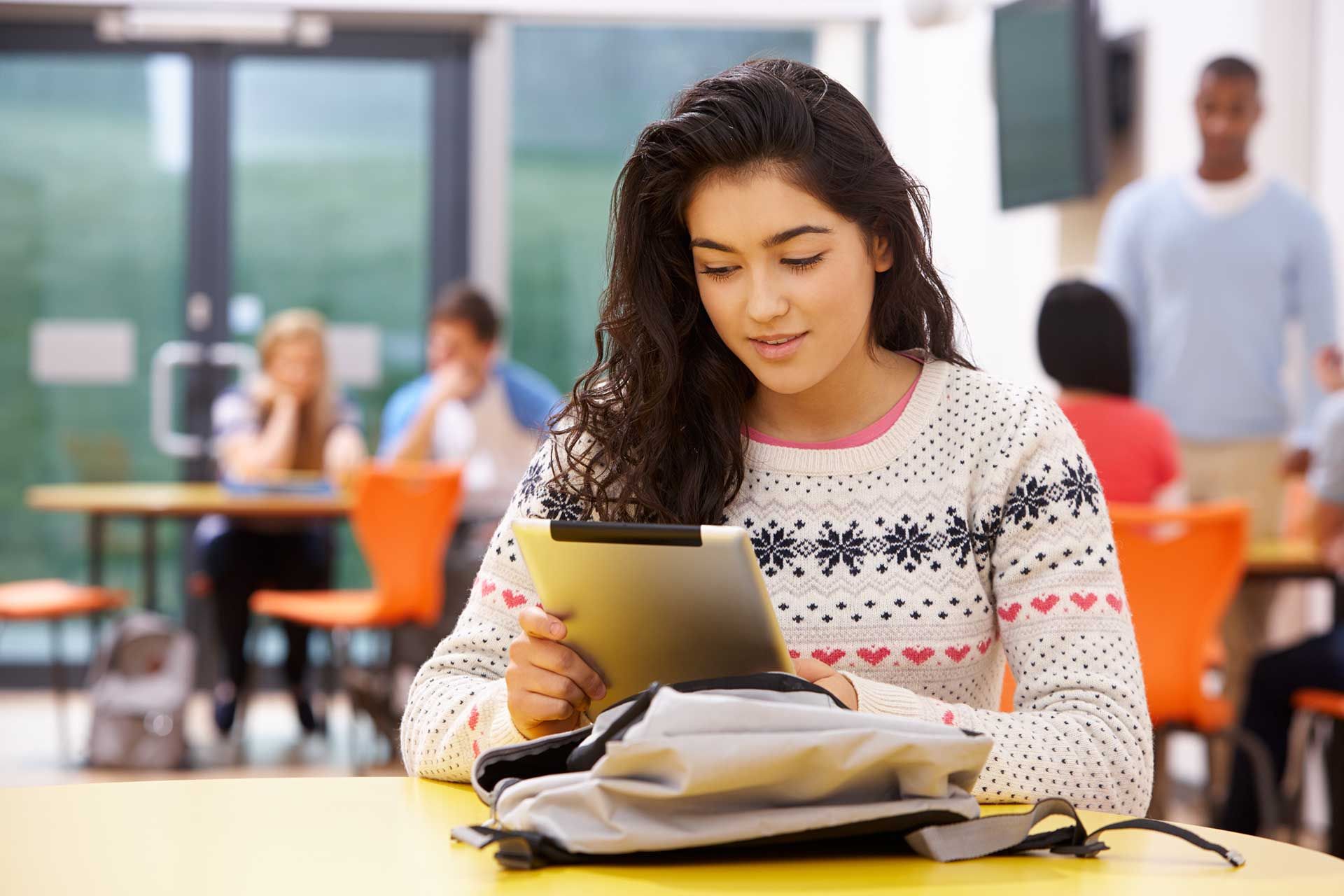 Female Teenage Student In Classroom With Digital Tablet 
