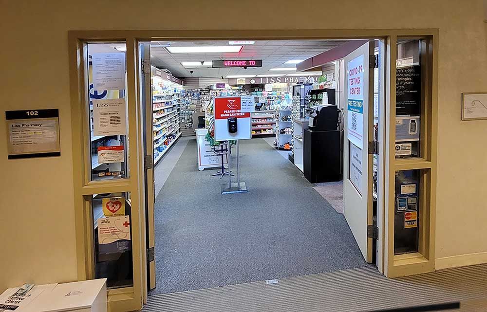 The inside of a pharmacy with a door open and a sign that says ' pharmacy ' on it.