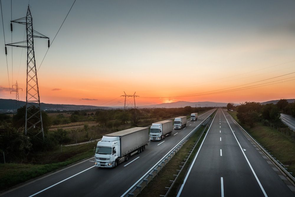 Trucks Driving on A Highway at Sunset with A Power Line on The Side — Haigh Truck & 4WD Repairs In Orange, NSW