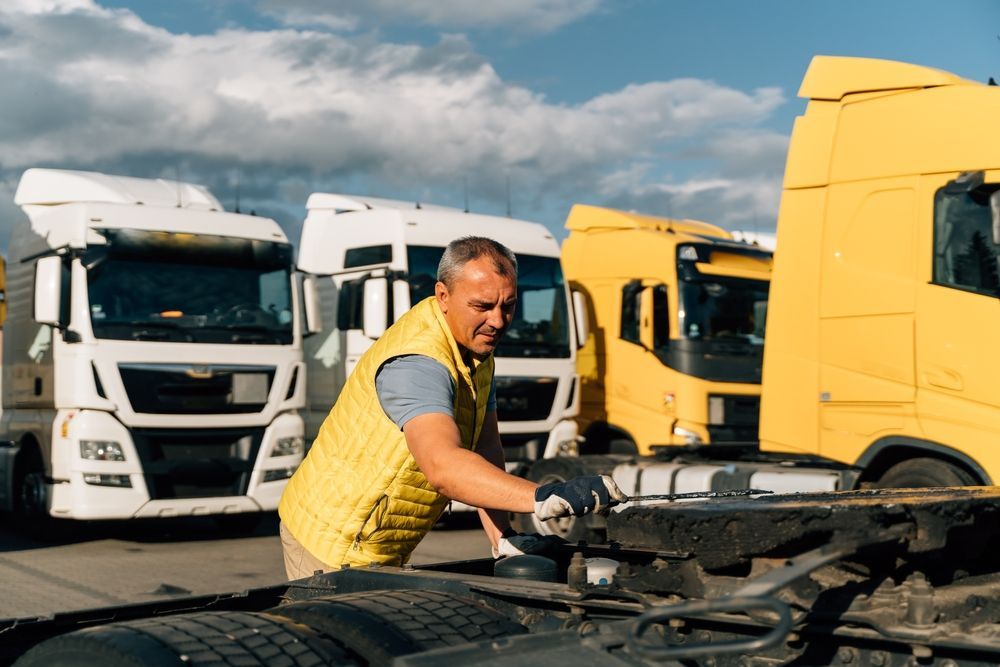 Man in Yellow Vest Inspecting a Semi-truck Hitch — Haigh Truck & 4WD Repairs In Orange, NSW