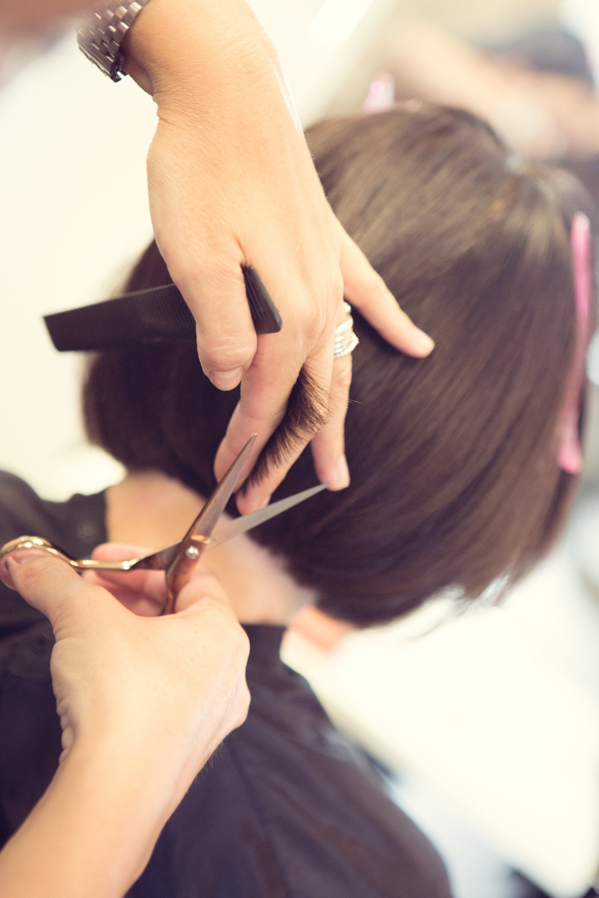 Eine Frau lässt sich beim Friseur die Haare schneiden