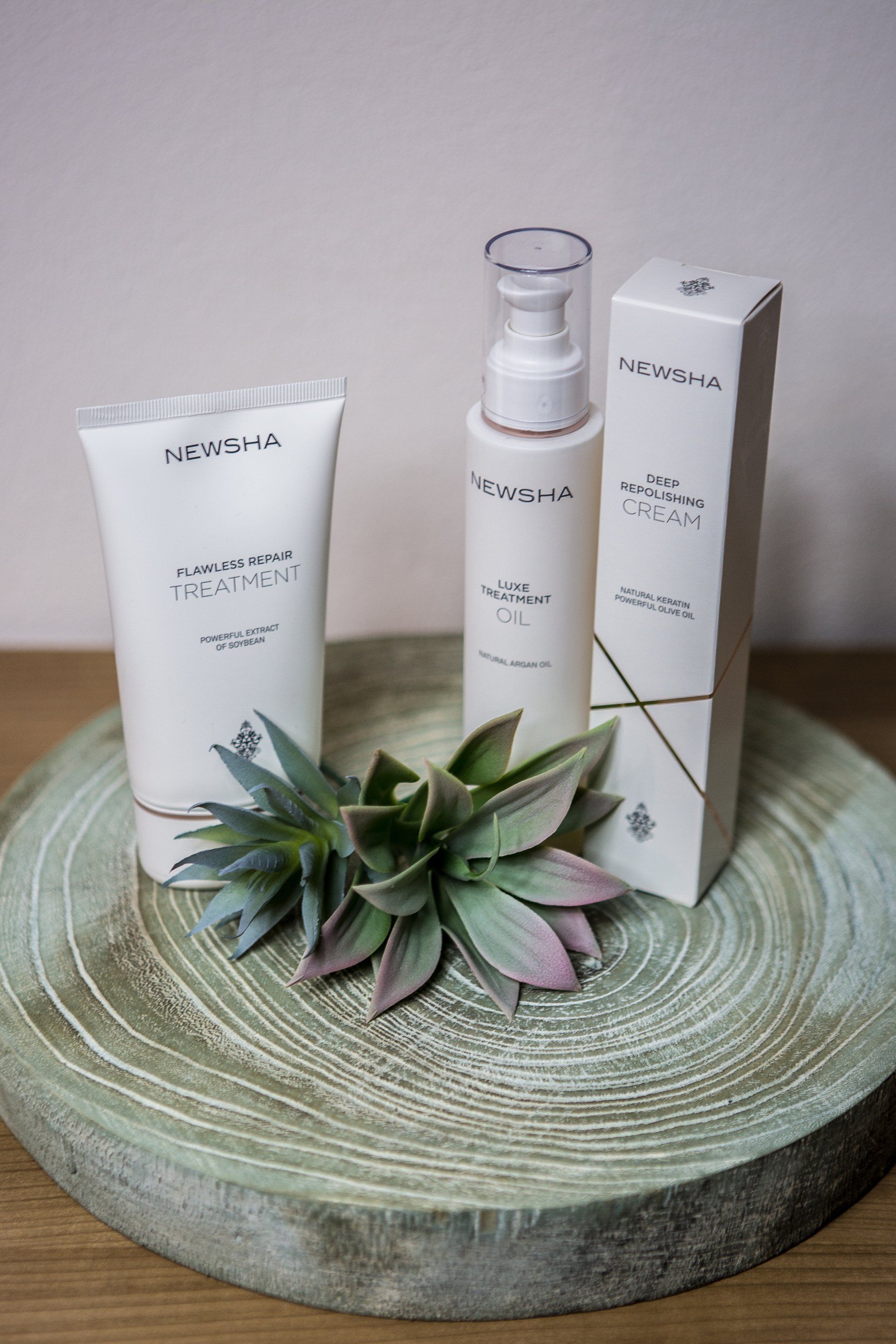 Zwei Flaschen und eine Schachtel Lotion stehen auf einem Holztisch.