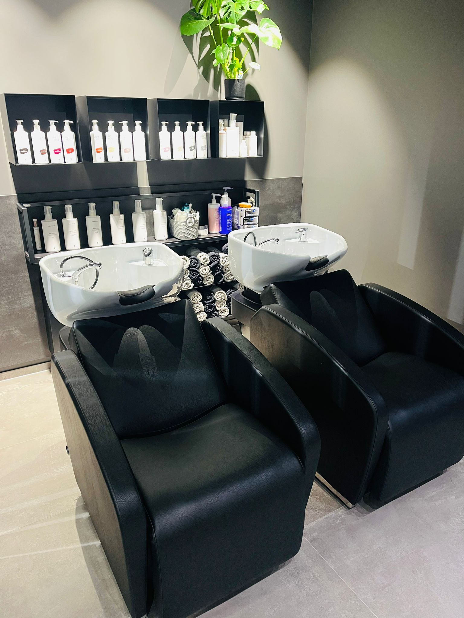 Ein Friseursalon mit zwei Stühlen und zwei Waschbecken.