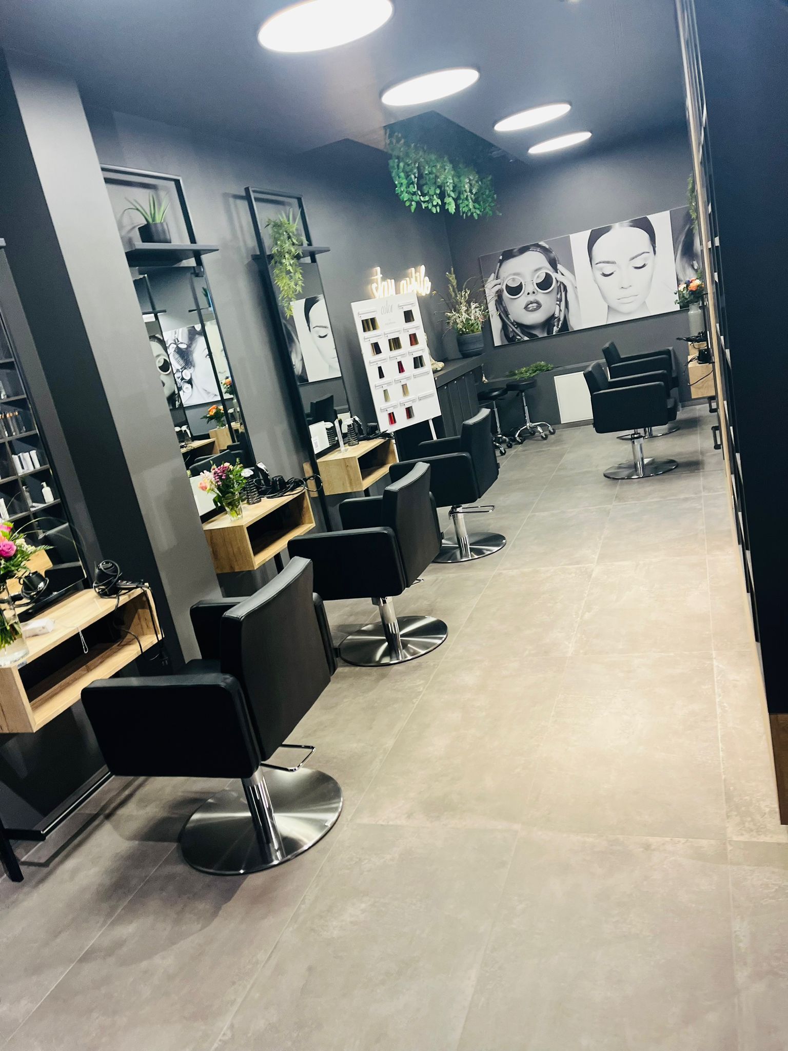 Ein Friseursalon mit vielen Stühlen und Spiegeln.