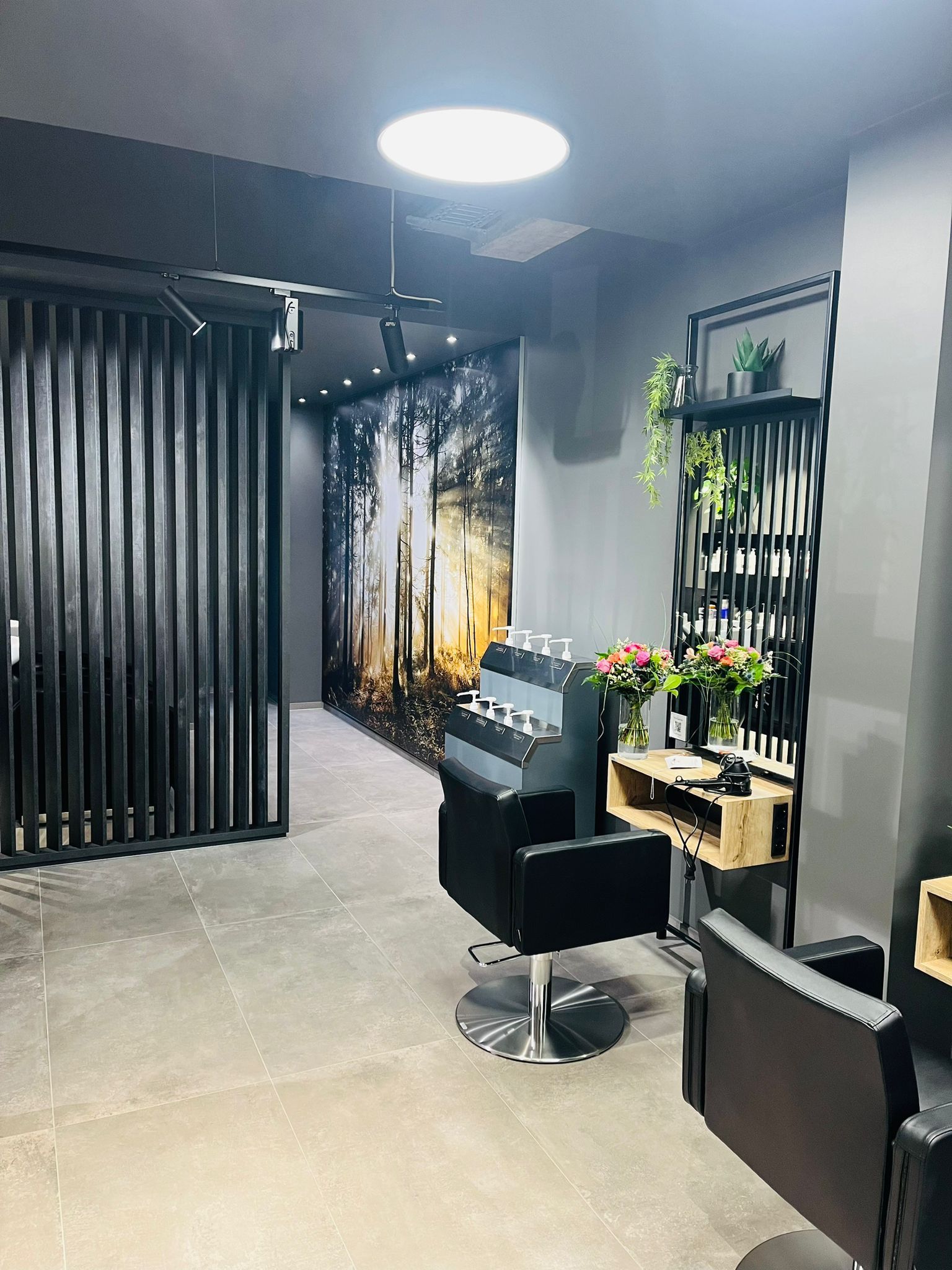 Ein Salon mit vielen Stühlen und Blumen an der Wand.