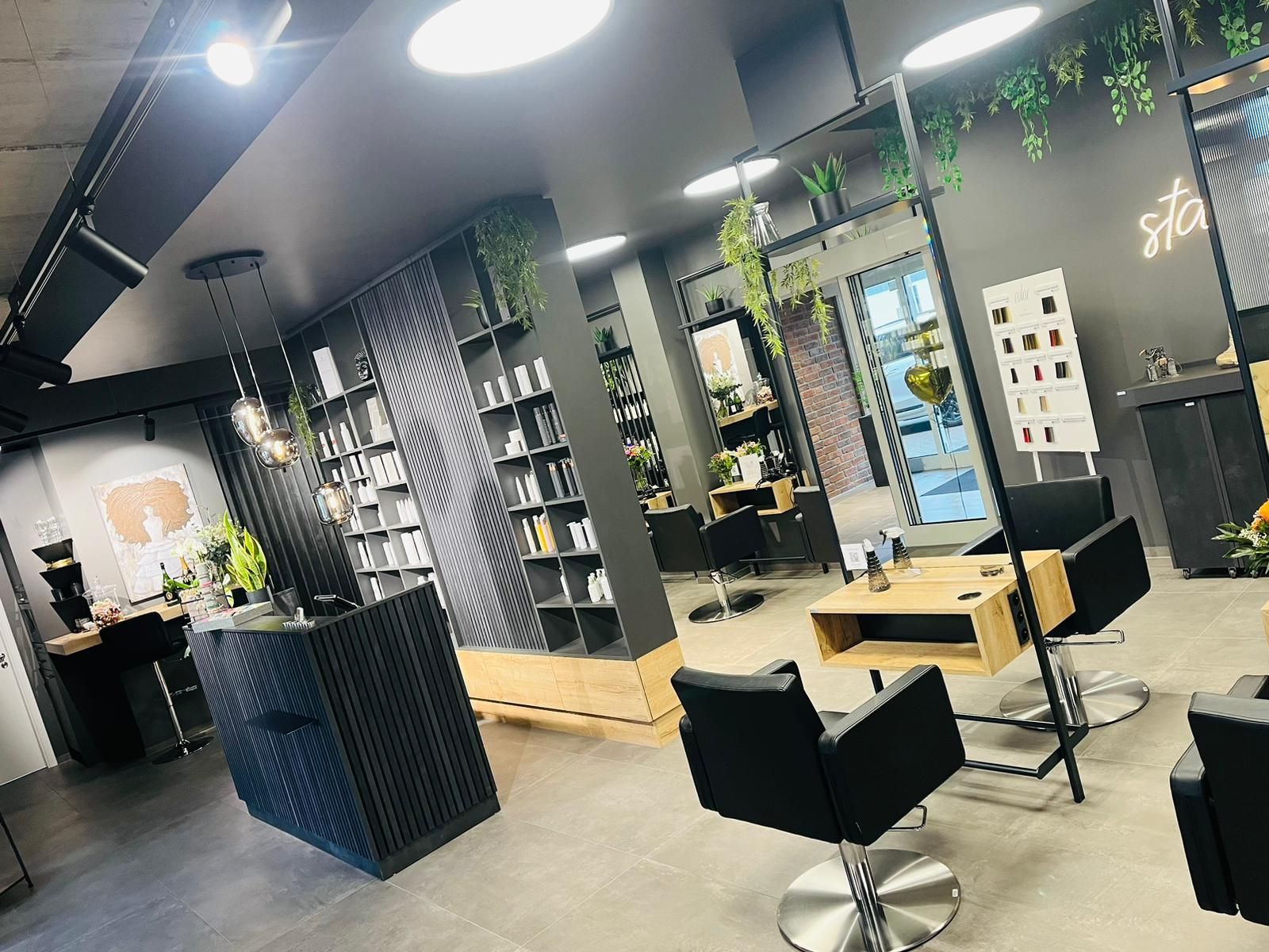 Ein Friseursalon mit vielen Stühlen und einem Tresen.