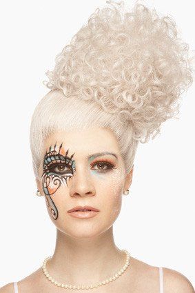 Eine Frau trägt eine weiße Perücke und eine Perlenkette.