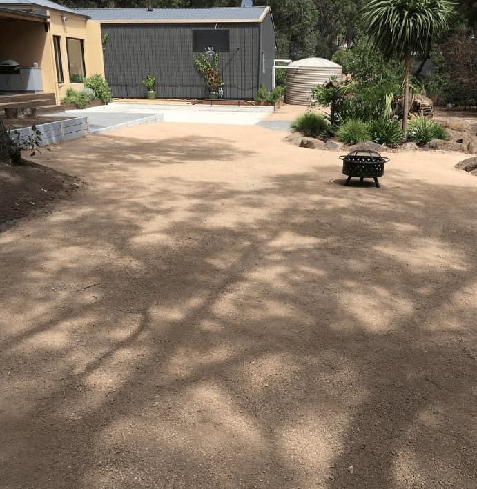 Gravel Yard With a Fire Pit, Next to a Building and Water Tank — The Soil Yard in Delacombe, VIC