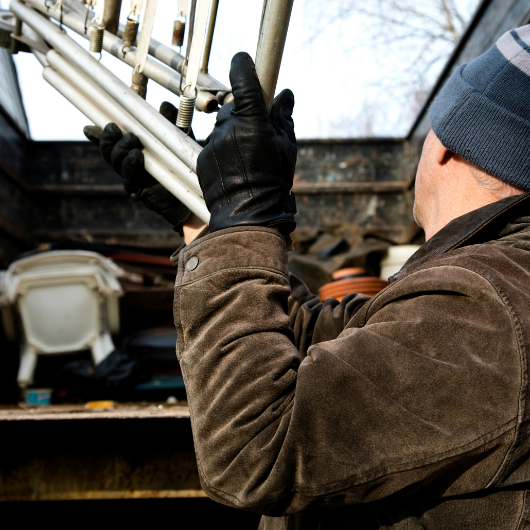 A man wearing gloves is holding a metal pole