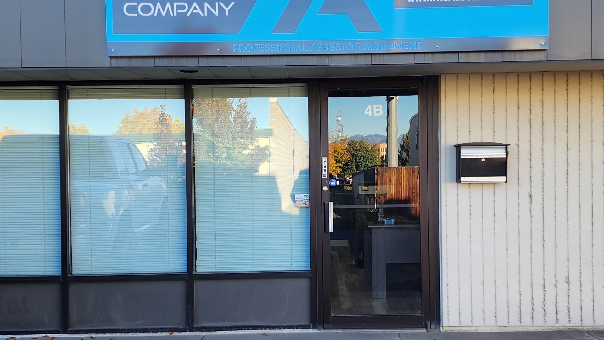 Exterior of an office building with a blue sign and frosted windows. Door marked with number 48.