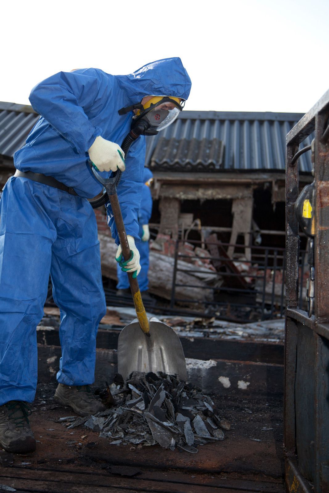 A man wearing a hard hat and goggles is standing in a room.