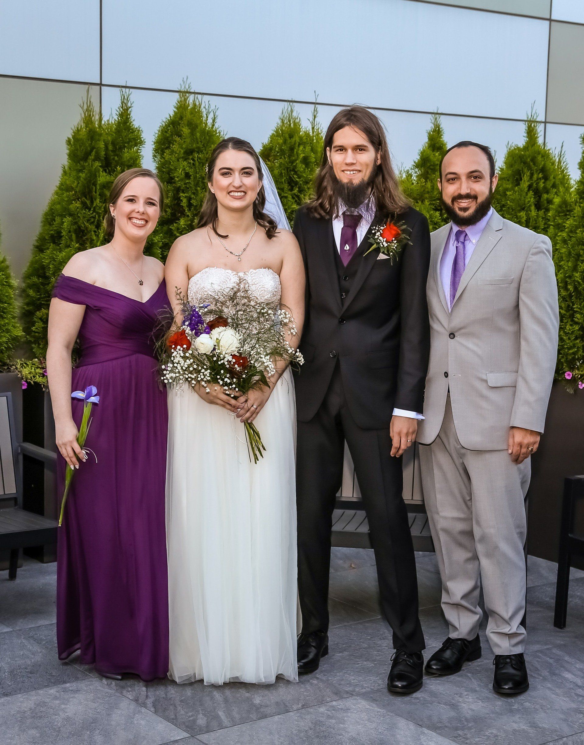 A bride and groom are posing for a picture with their wedding party.