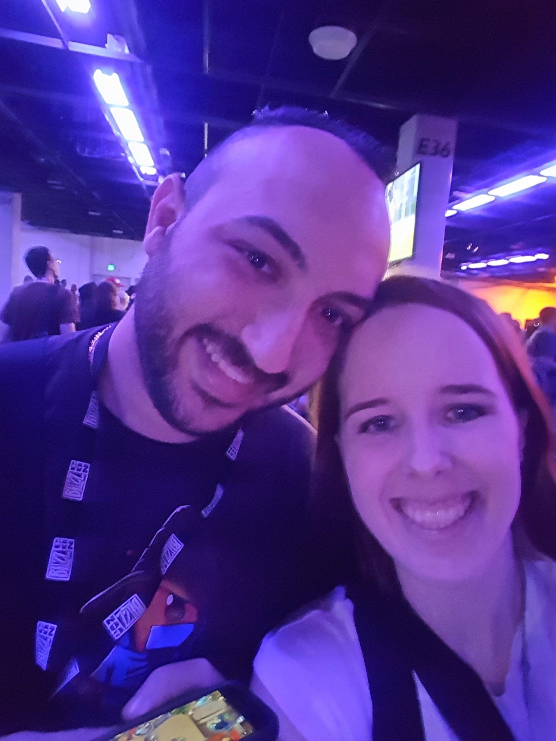 A man and a woman are posing for a picture in a dark room.