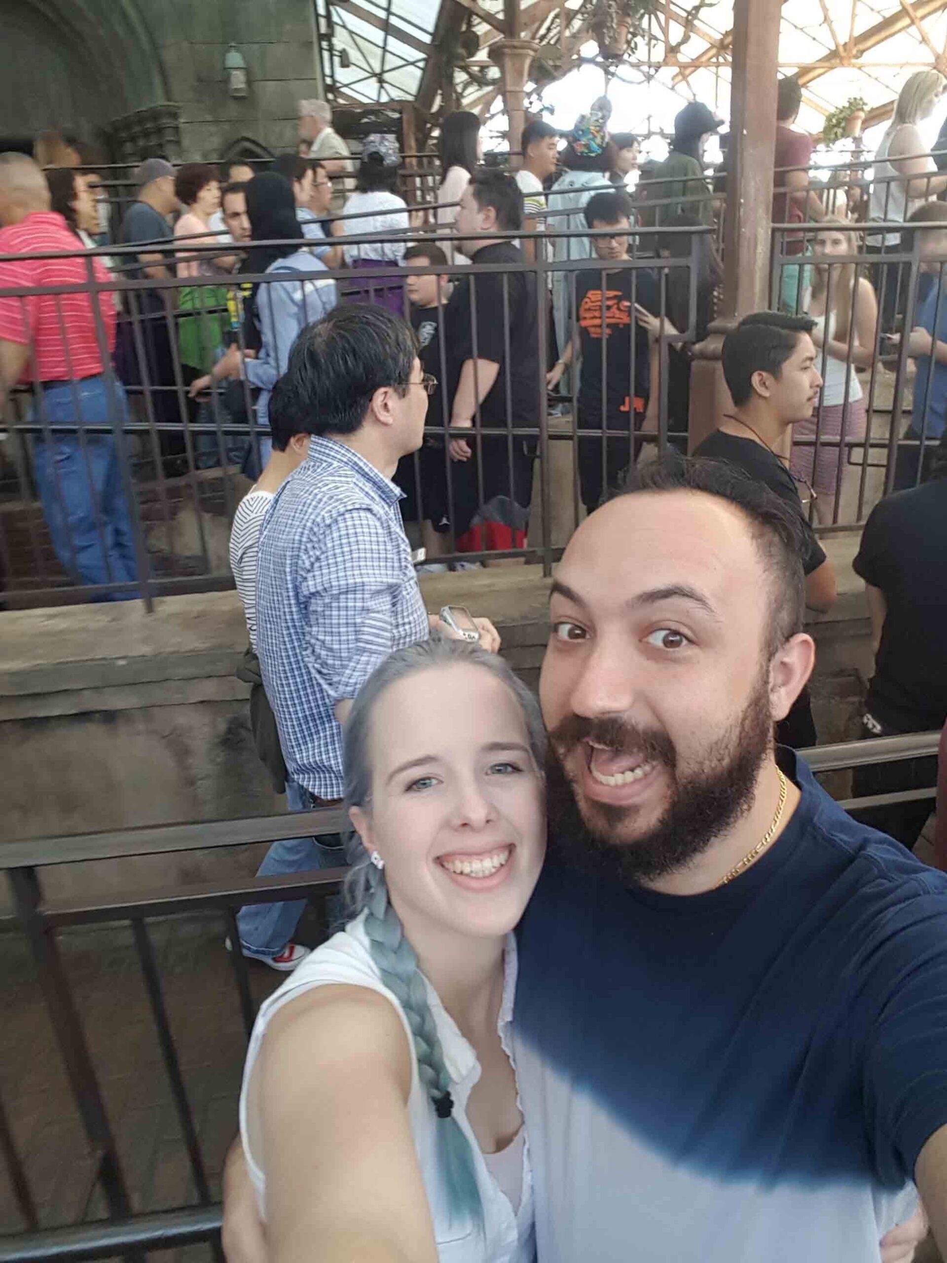 A man and a woman are posing for a picture in front of a crowd of people.