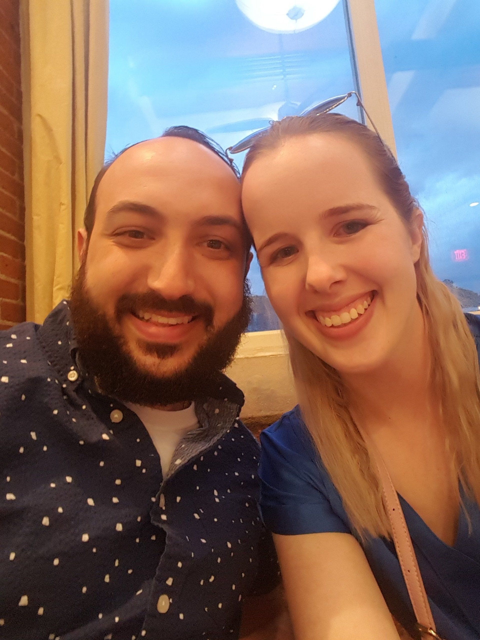 A man and a woman are posing for a picture and smiling