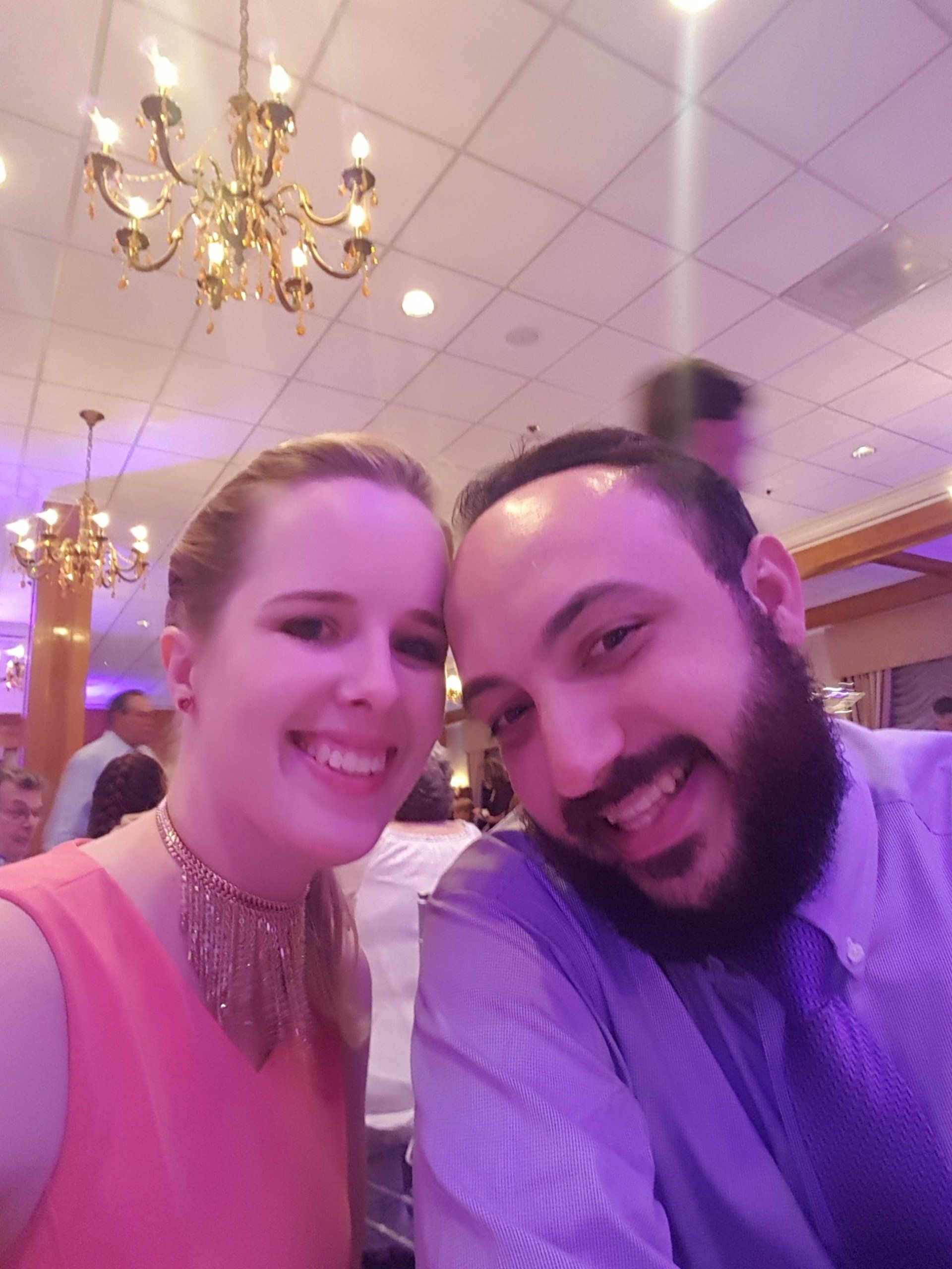 A man and a woman are posing for a picture together in a room.