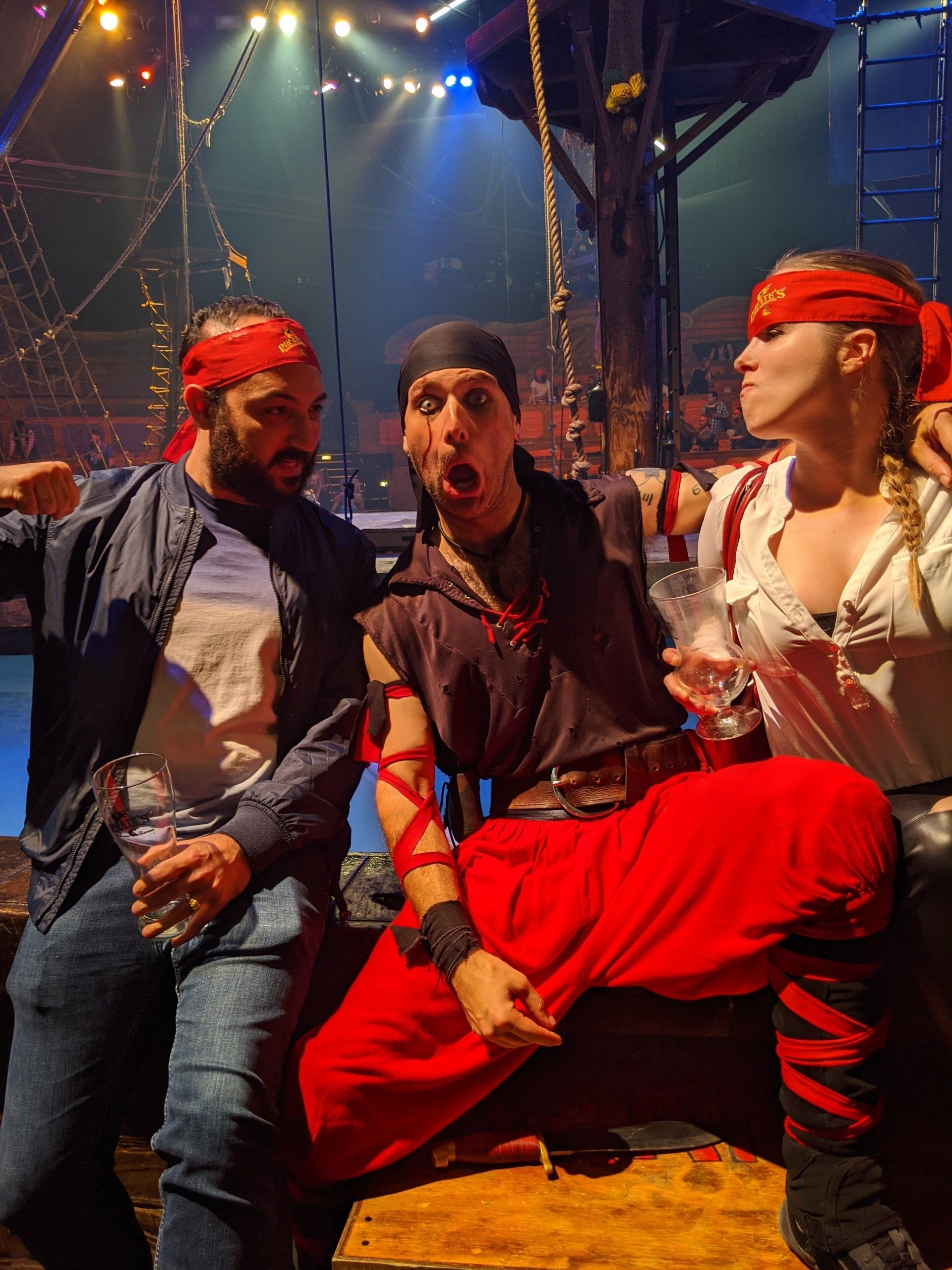 A group of people dressed as pirates are sitting next to each other on a stage.