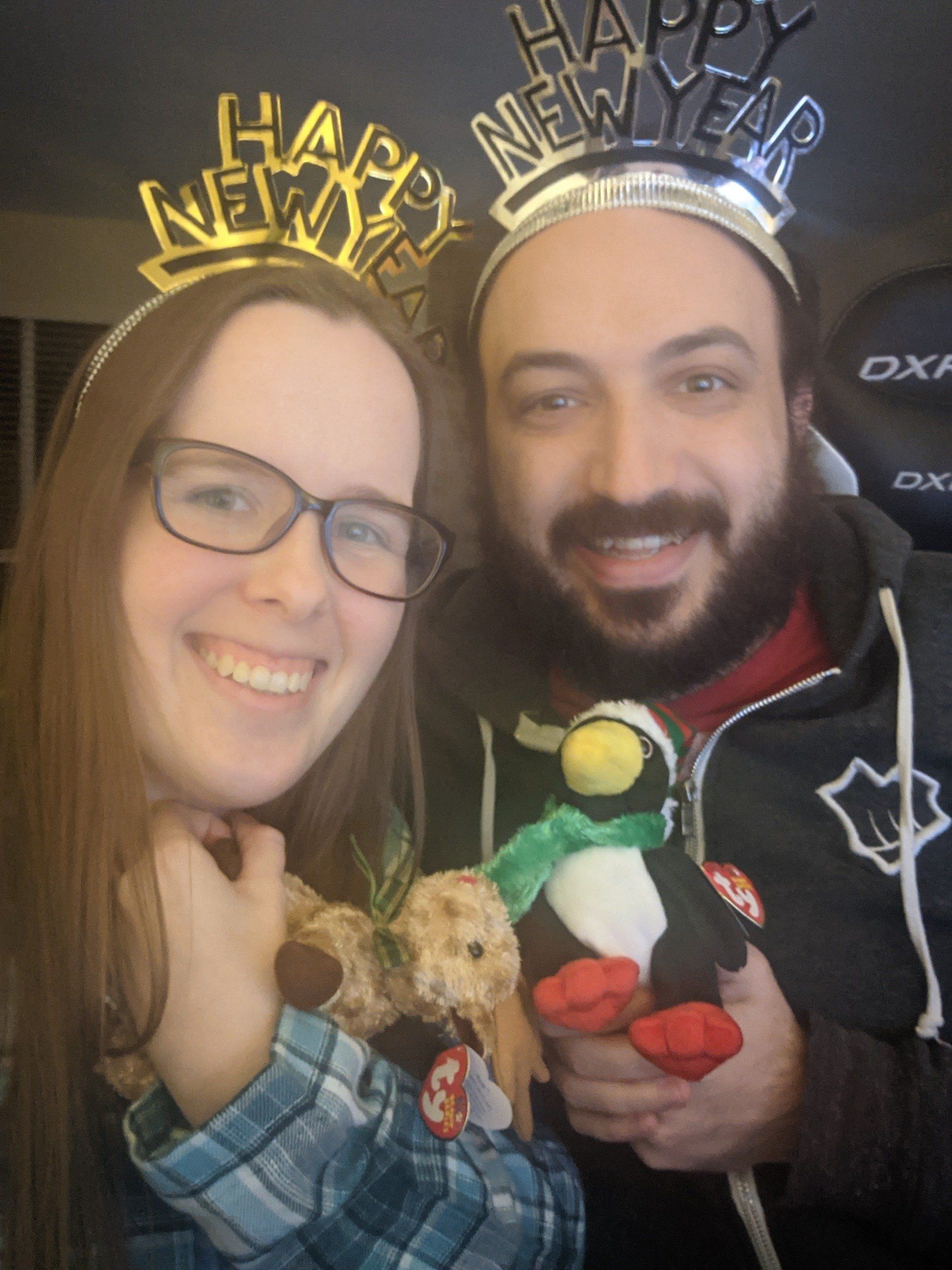 A man and a woman wearing happy new year headbands
