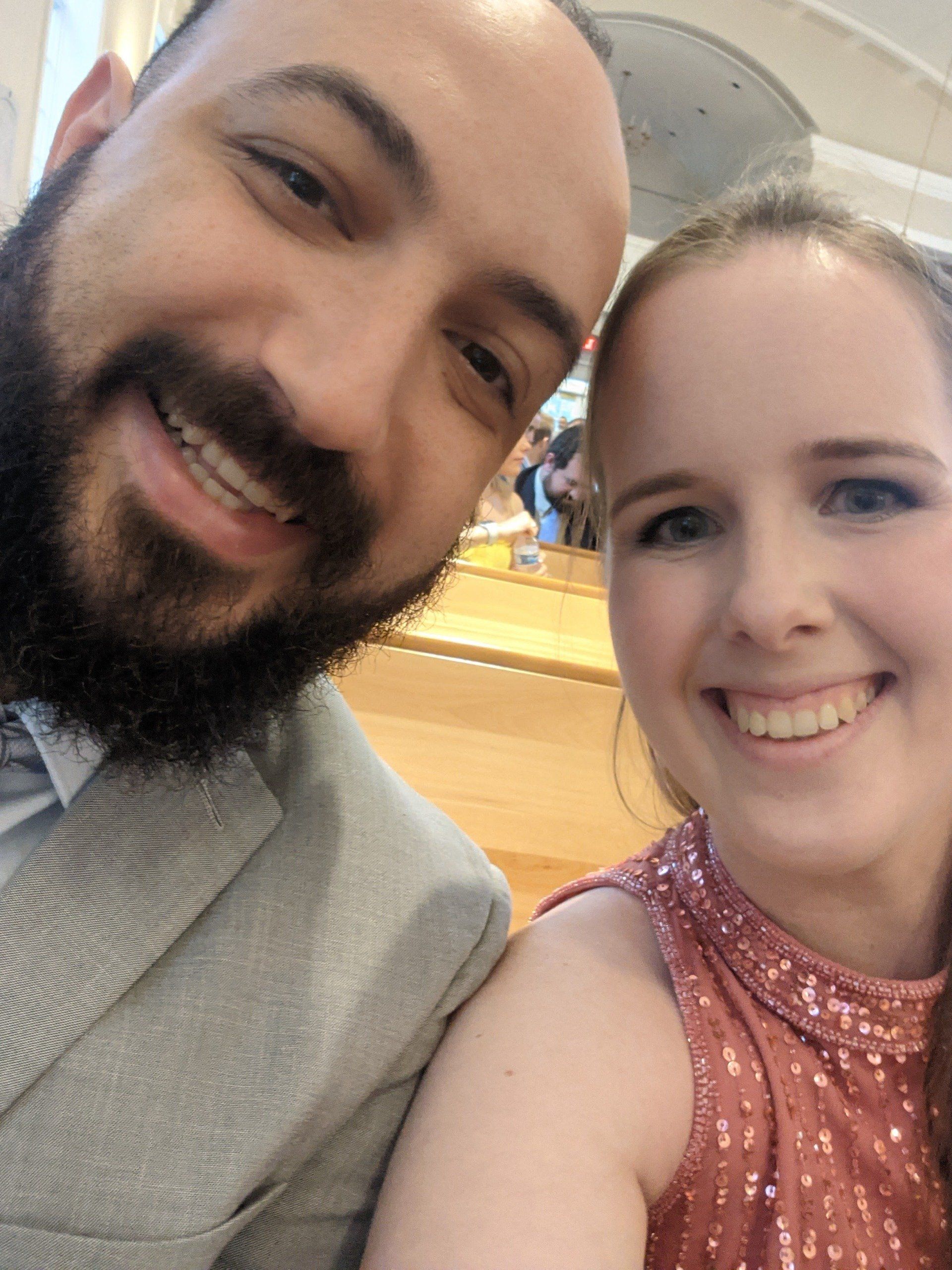 A man and a woman are posing for a picture together and smiling.