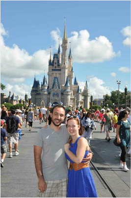 A man and a woman pose in front of a castle
