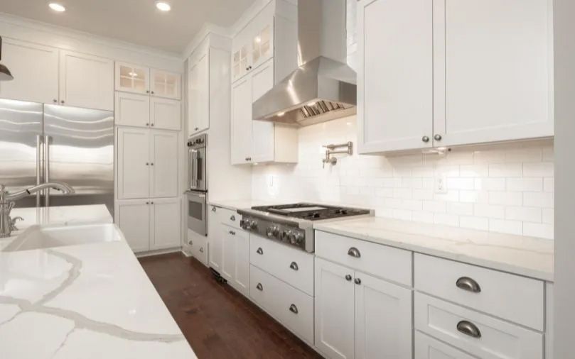 A kitchen with white cabinets and stainless steel appliances.