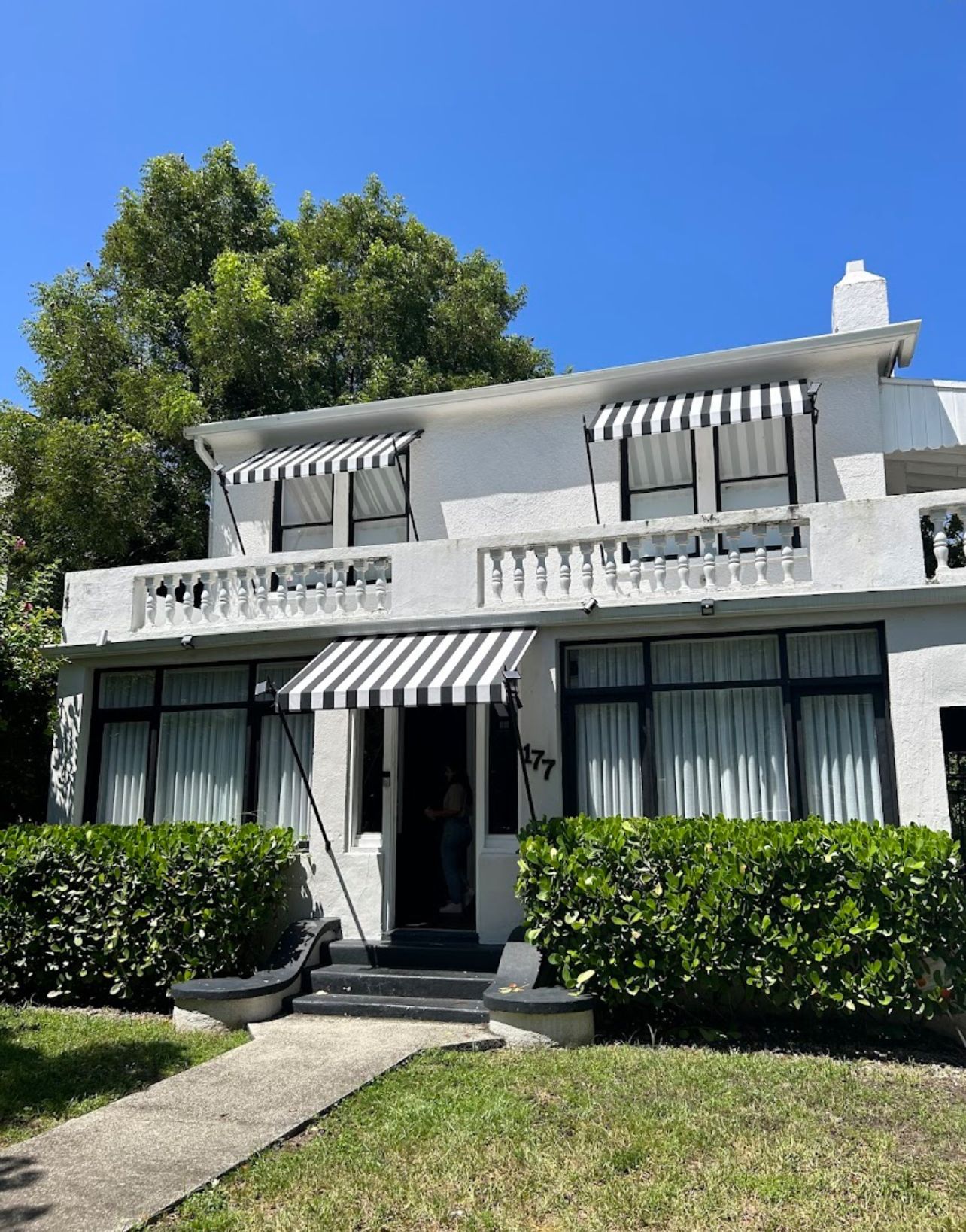A white building with a gray awning on the side of it.