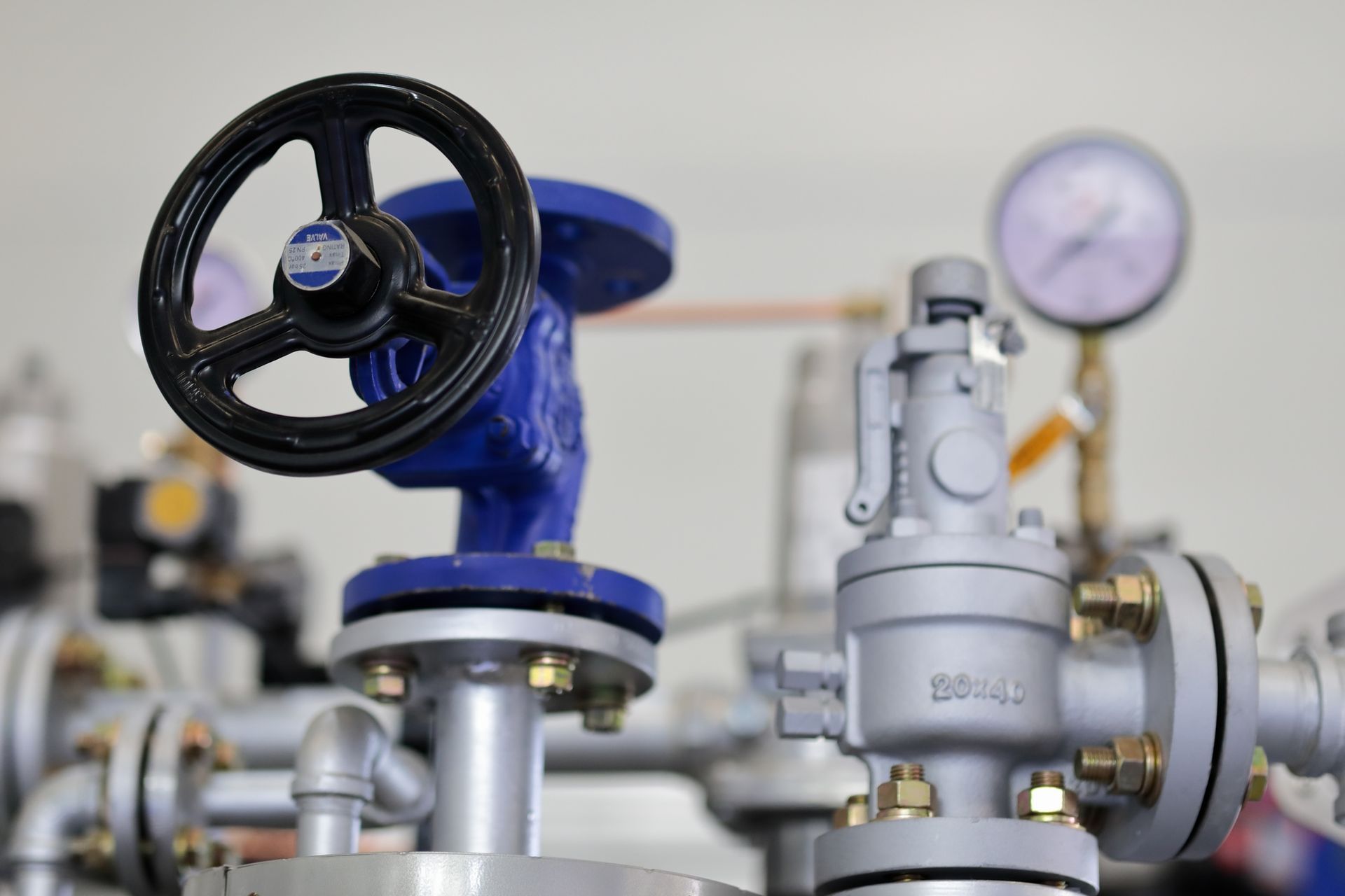 A close up of a valve with a steering wheel on top of it.