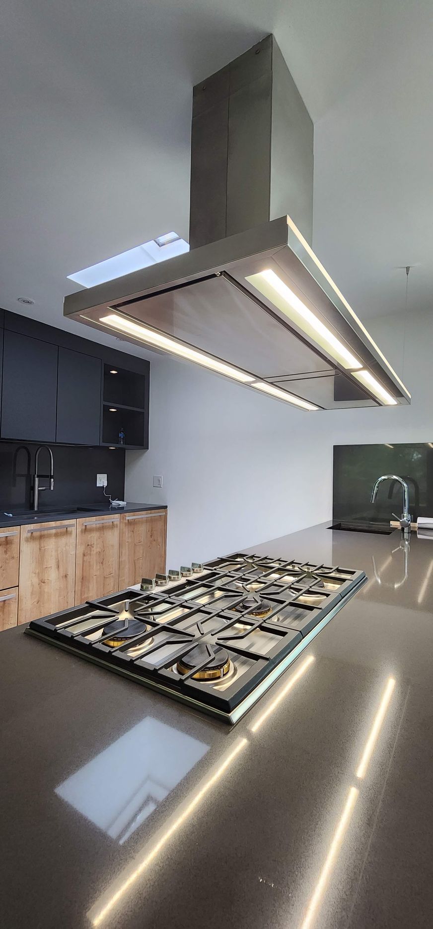 A kitchen with white cabinets , stainless steel appliances , a sink , and a refrigerator.