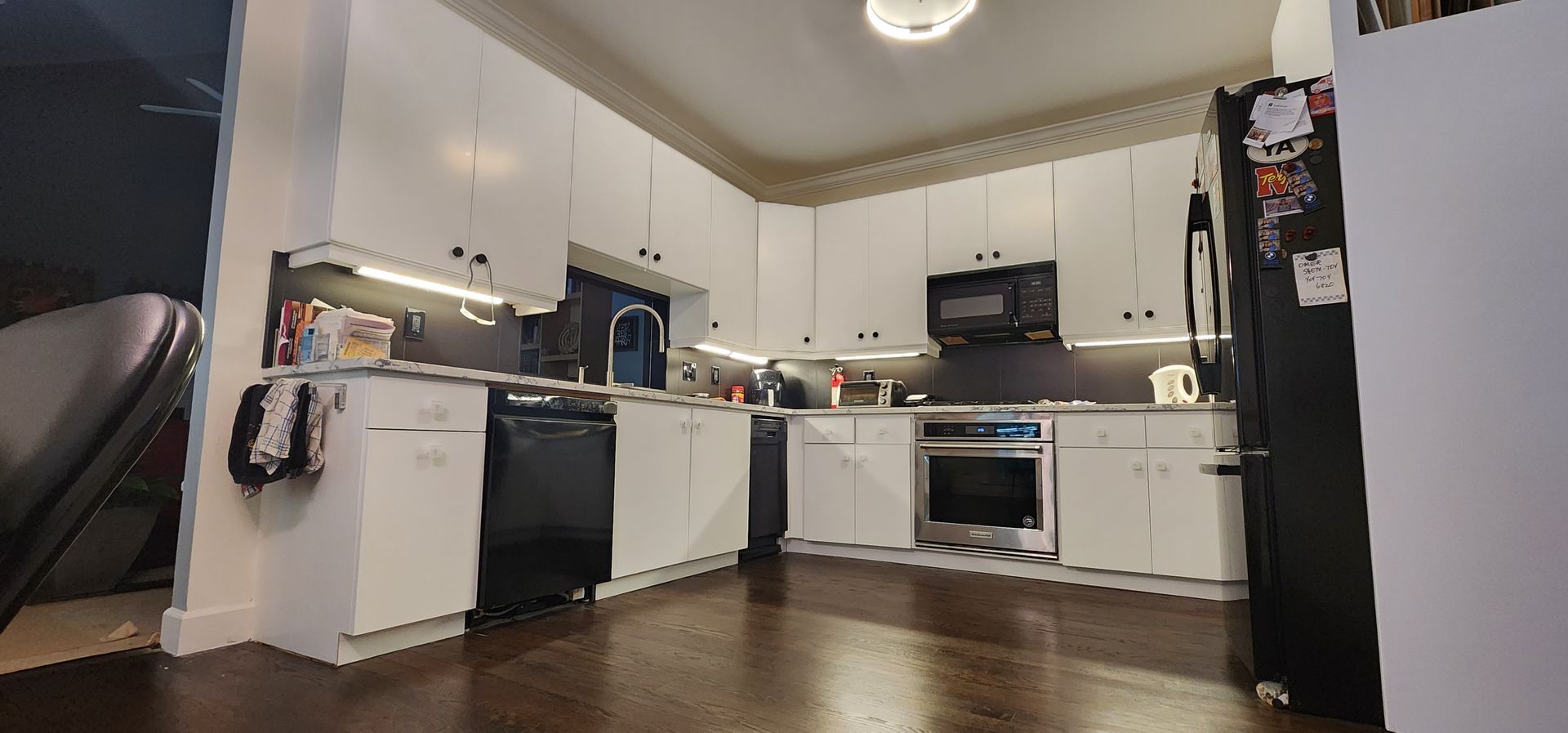 A kitchen with white cabinets and black appliances