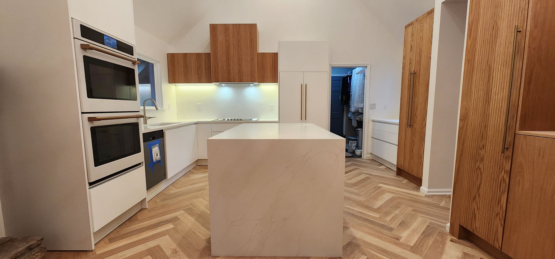 A kitchen with a large island in the middle and wooden cabinets.