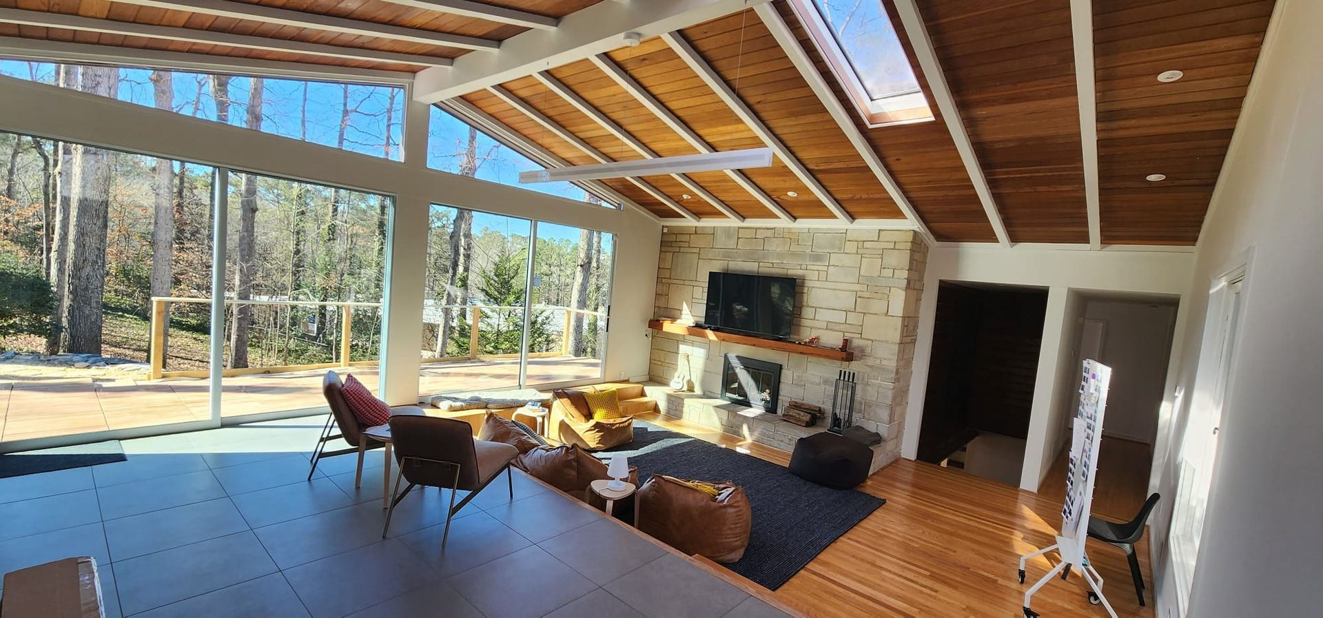 A living room with a lot of windows and a wooden ceiling.