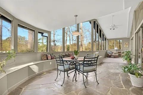 A living room with wicker furniture and lots of windows