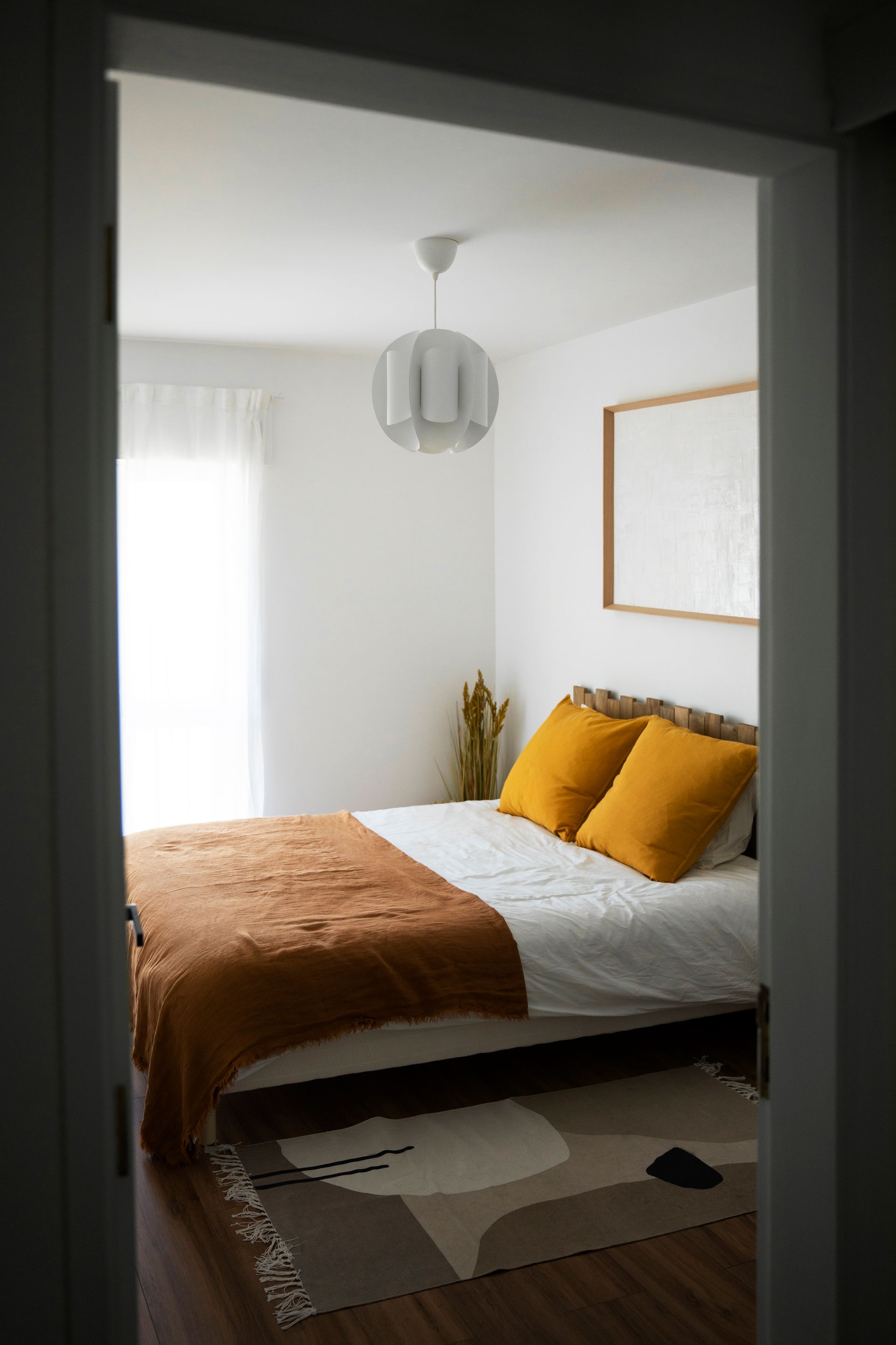 A hotel room with a bed , chair and window.