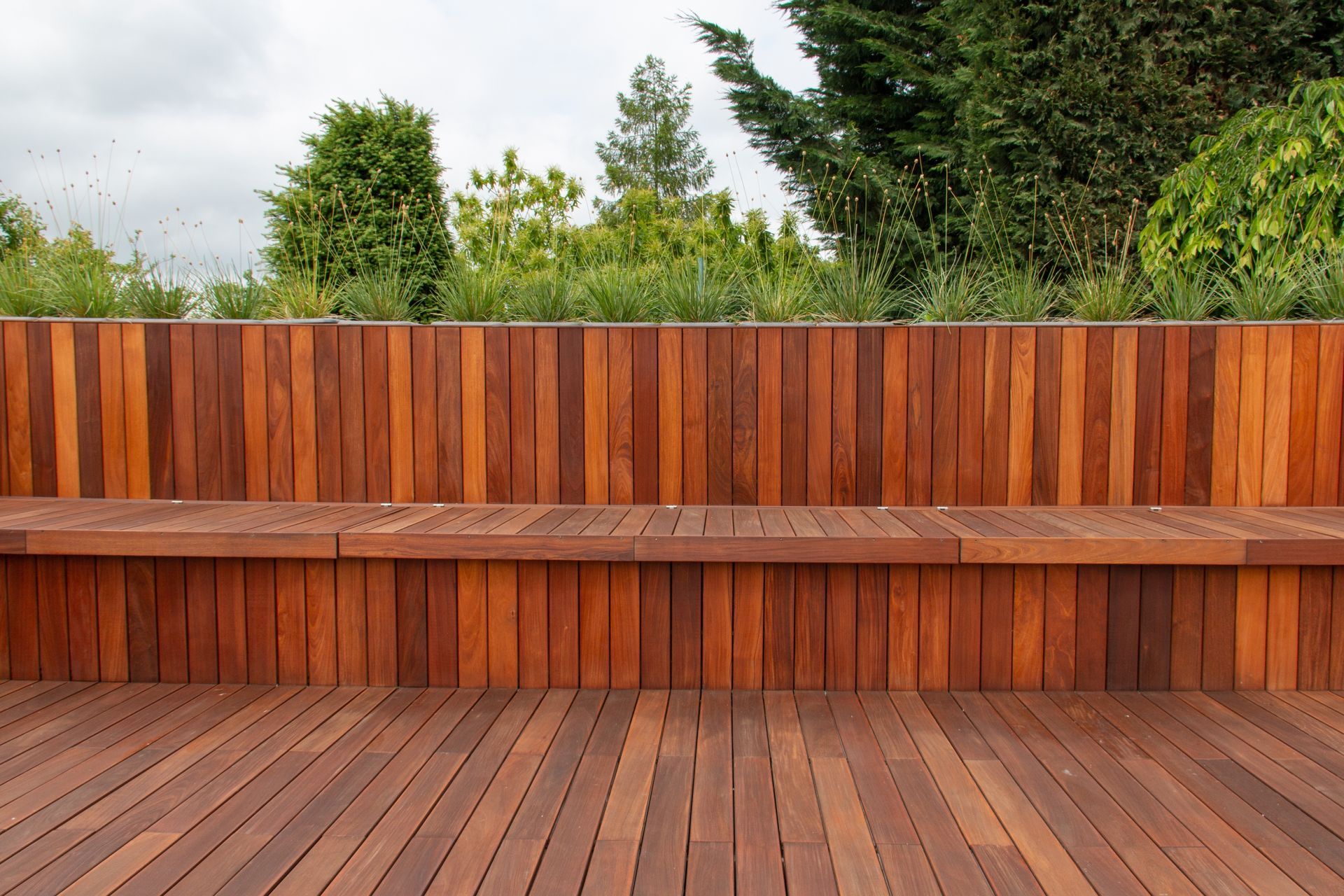 A wooden deck with a wooden bench in the background