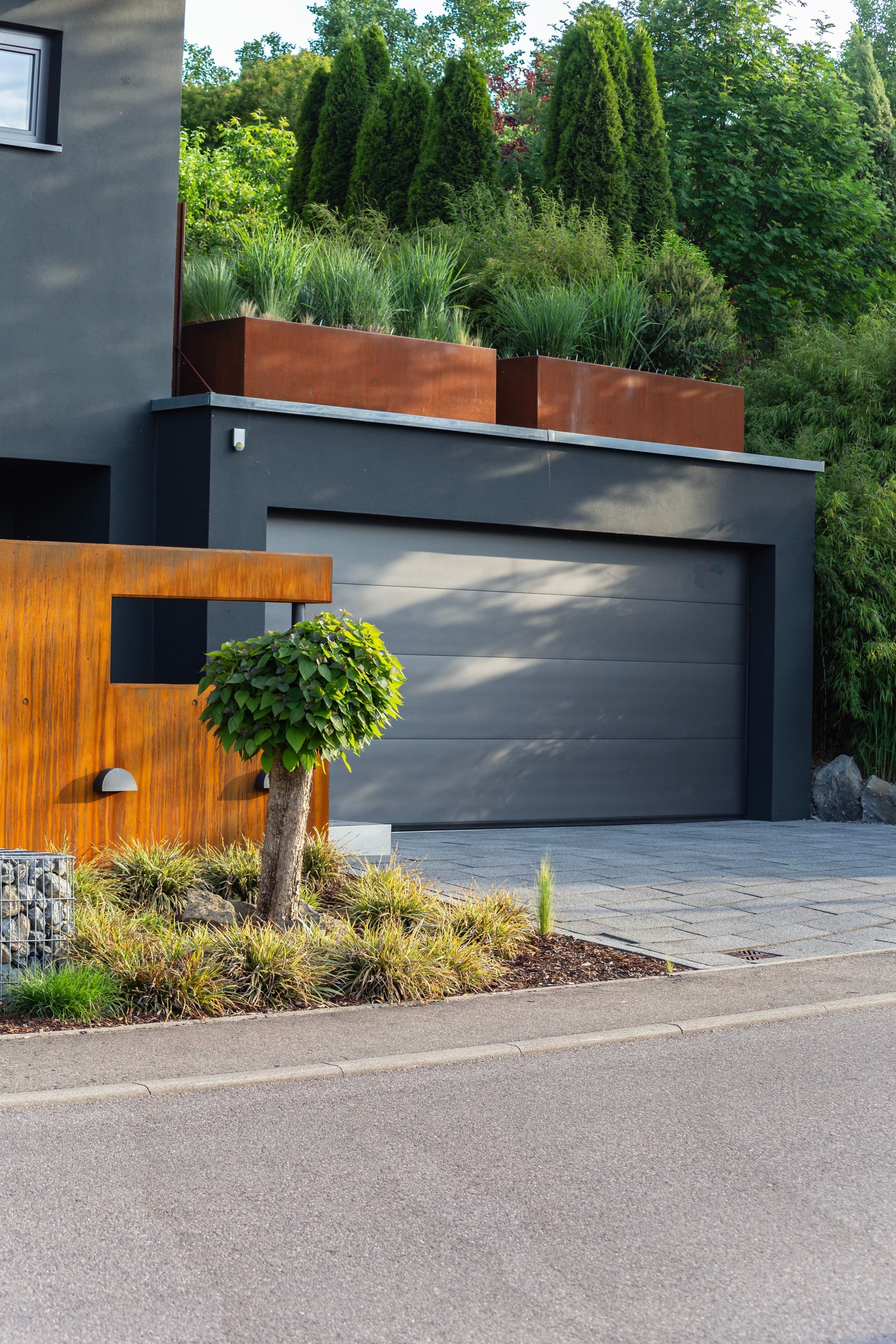 A house with a garage and a tree in front of it