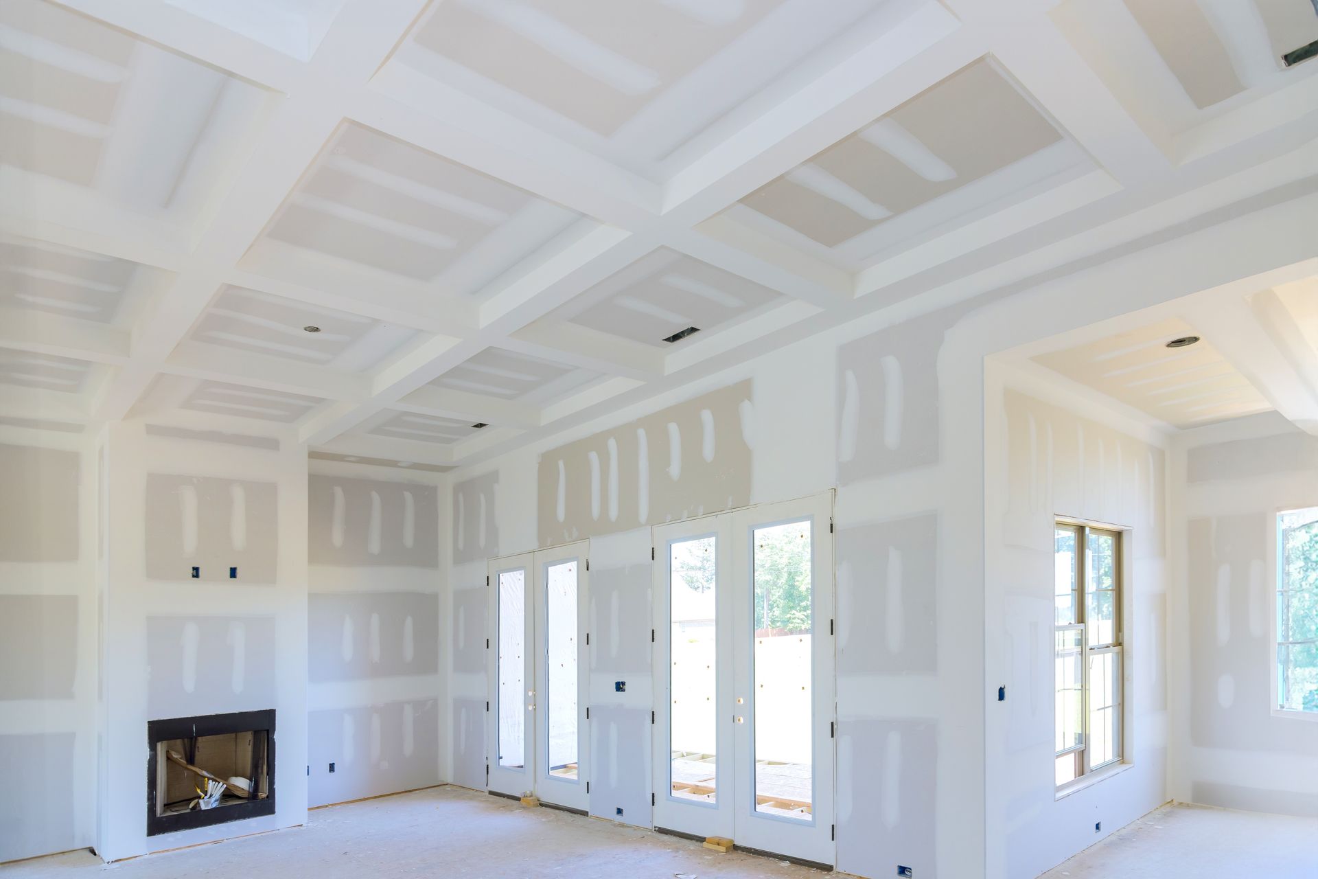 A living room in a house under construction with drywall on the walls and ceiling.