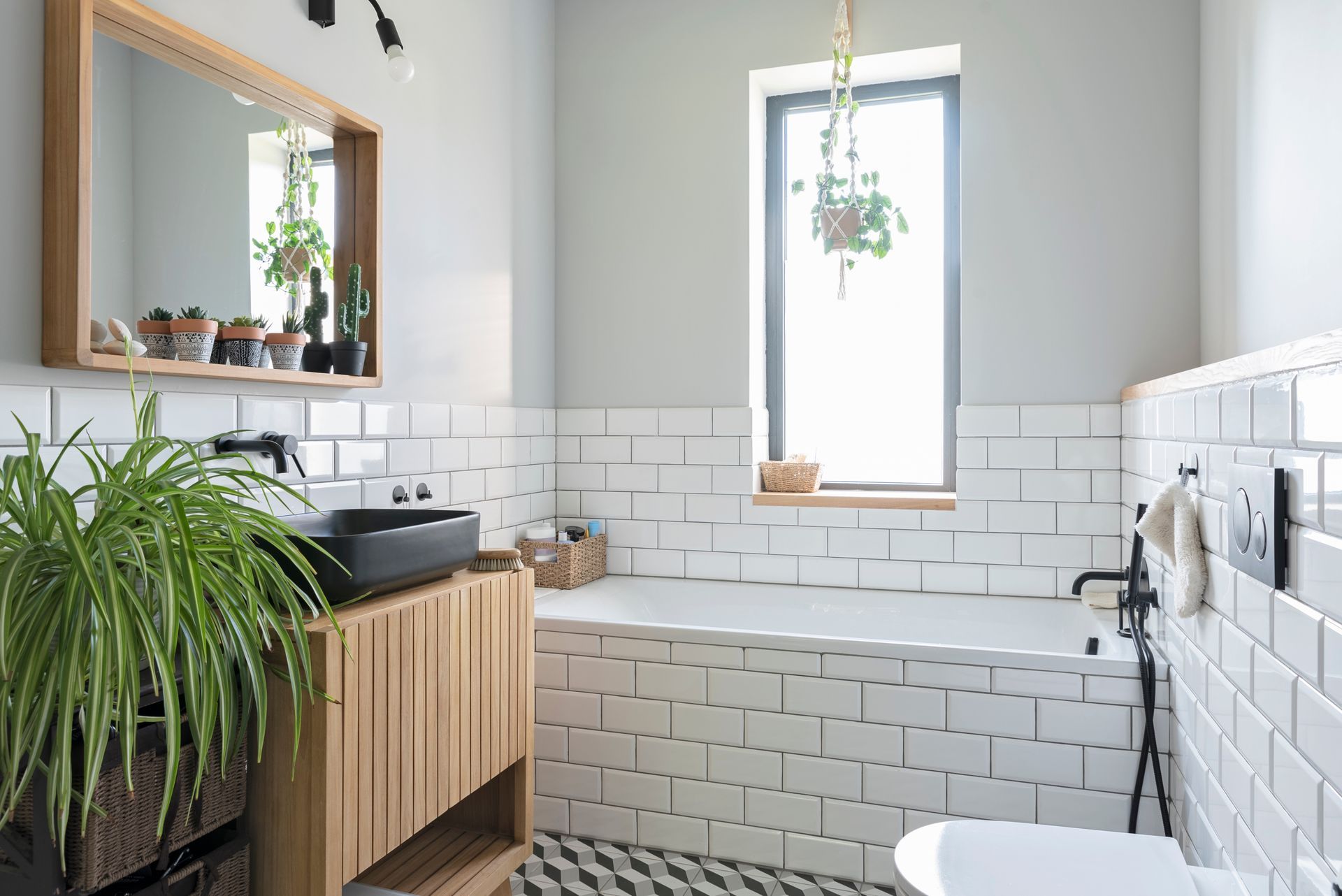 A bathroom with white tiles , a sink , a toilet , and a window.