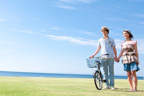 young couple holding hands by a bicycle