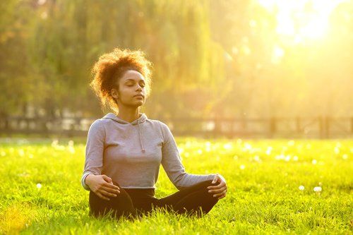 woman meditating in field