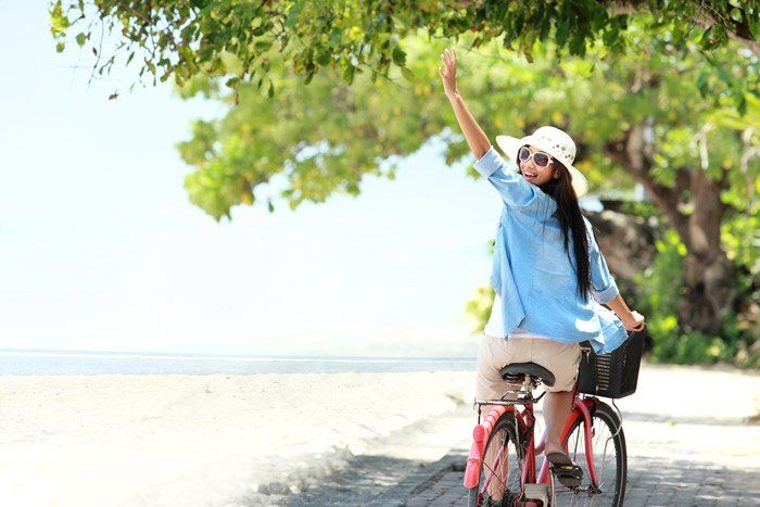 happy woman waving on bike