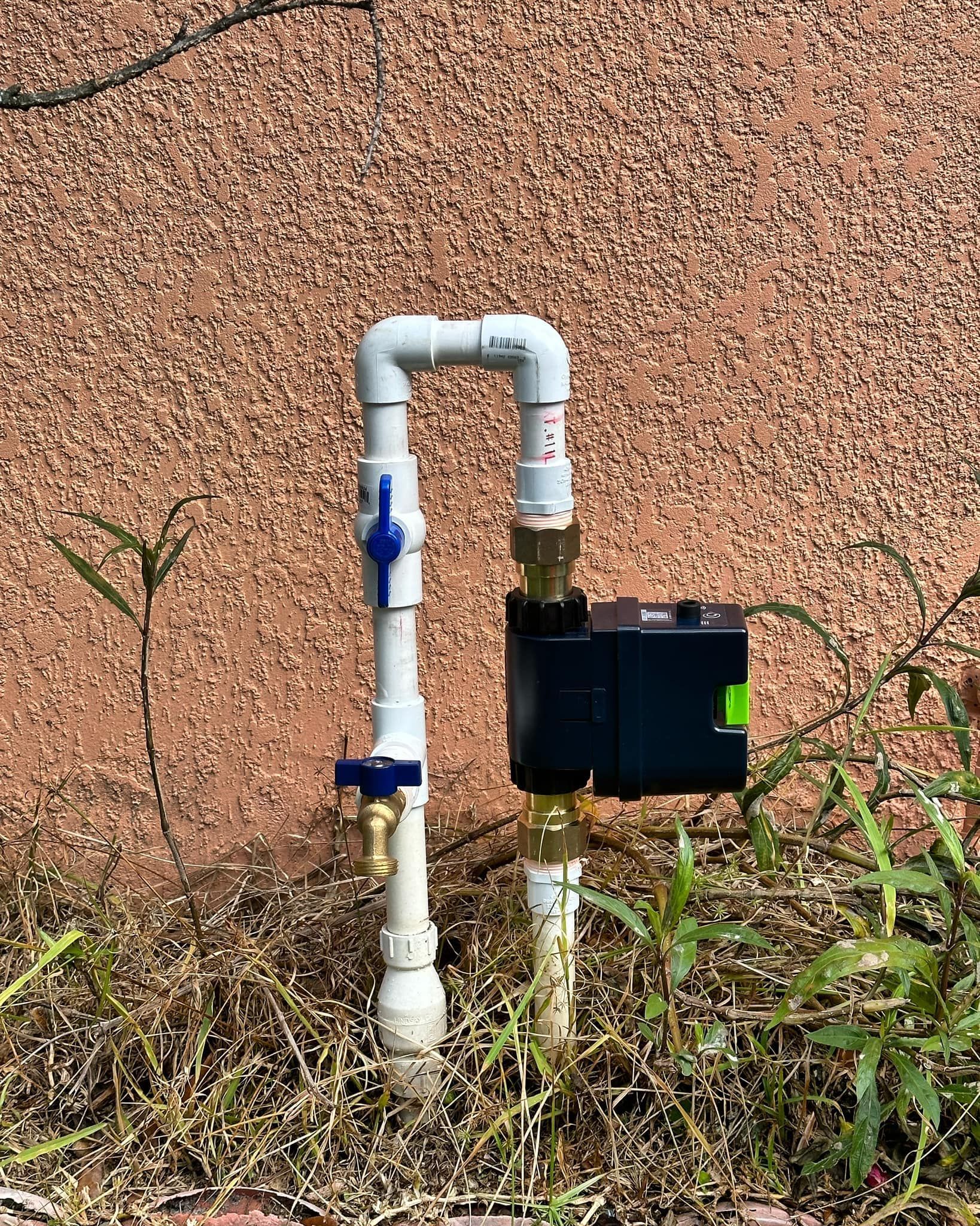 A white pipe with a blue valve attached to it