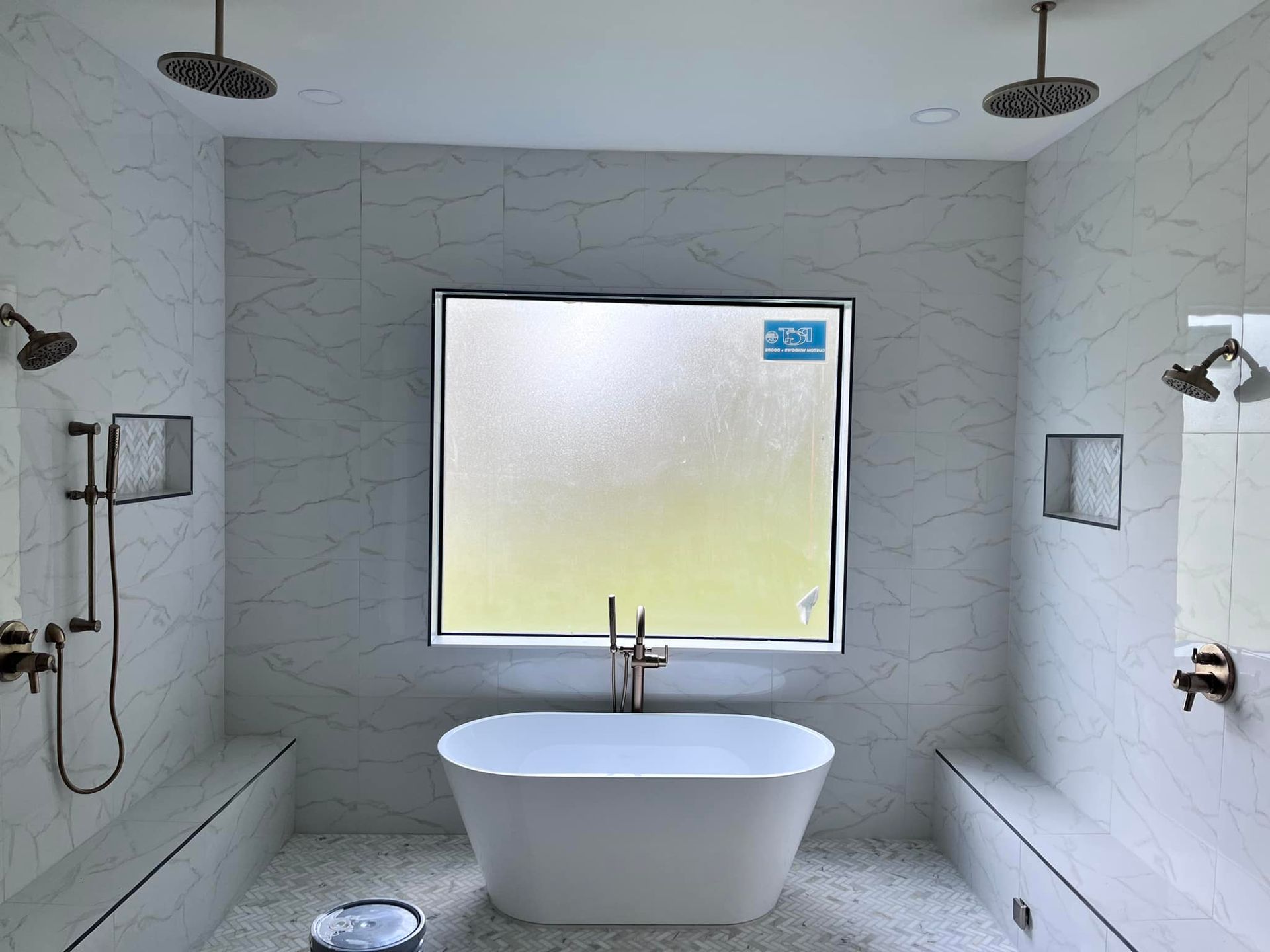 A bathroom with two showers and a bathtub