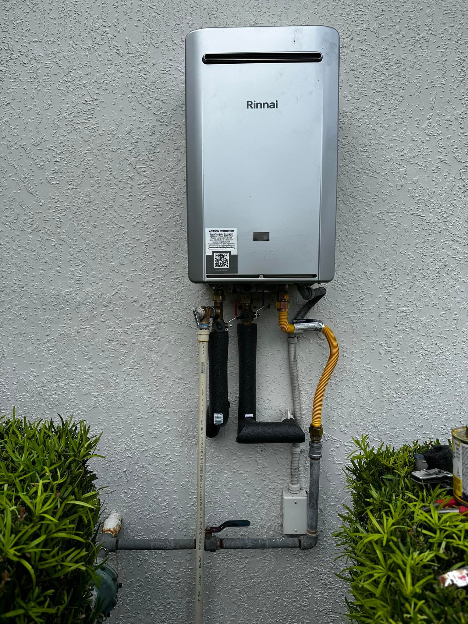 A rinnai water heater is attached to a wall