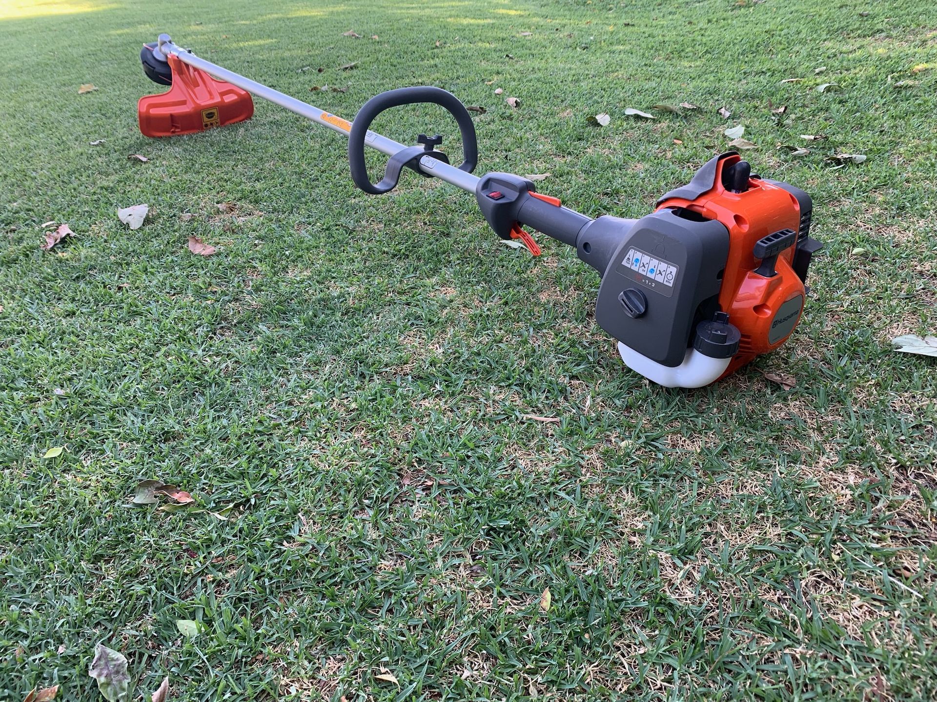 Orange and Gray Husqvarna Weed Trimmer on a Wood Floor in a Retail Store — M.M & Mechanical in Dubbo, NSW