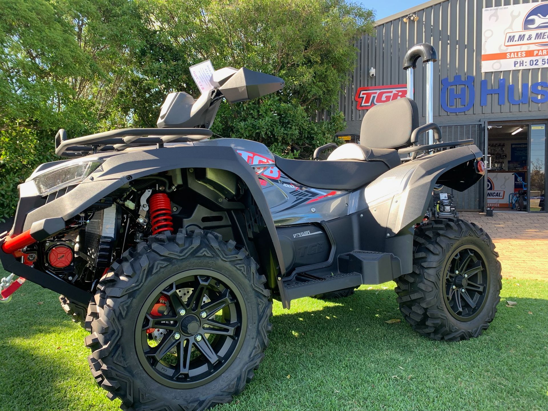 Three ATVs and a UTV Parked Outside a Gray Industrial Building — M.M & Mechanical in Dubbo, NSW