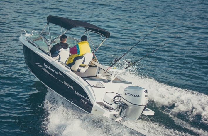 Boat with two people on open water, black awning, silver Honda engine— M.M & Mechanical in Dubbo, NSW