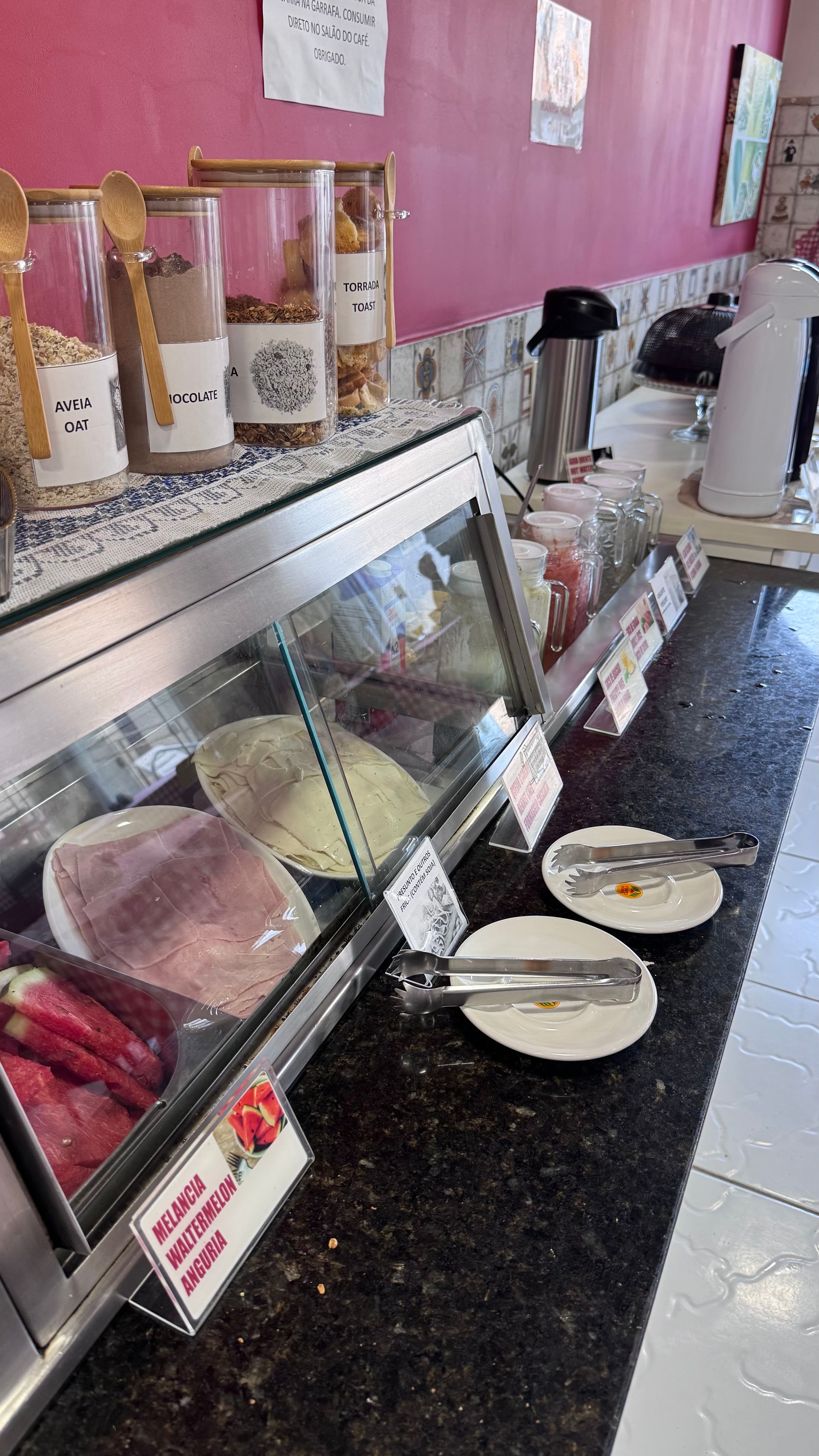 Vitrine de sorveteria com diversos sabores e tigelas sobre um balcão preto.
