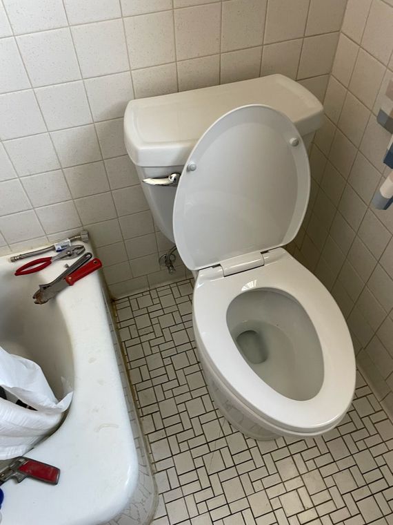 A toilet is sitting next to a bathtub in a bathroom.