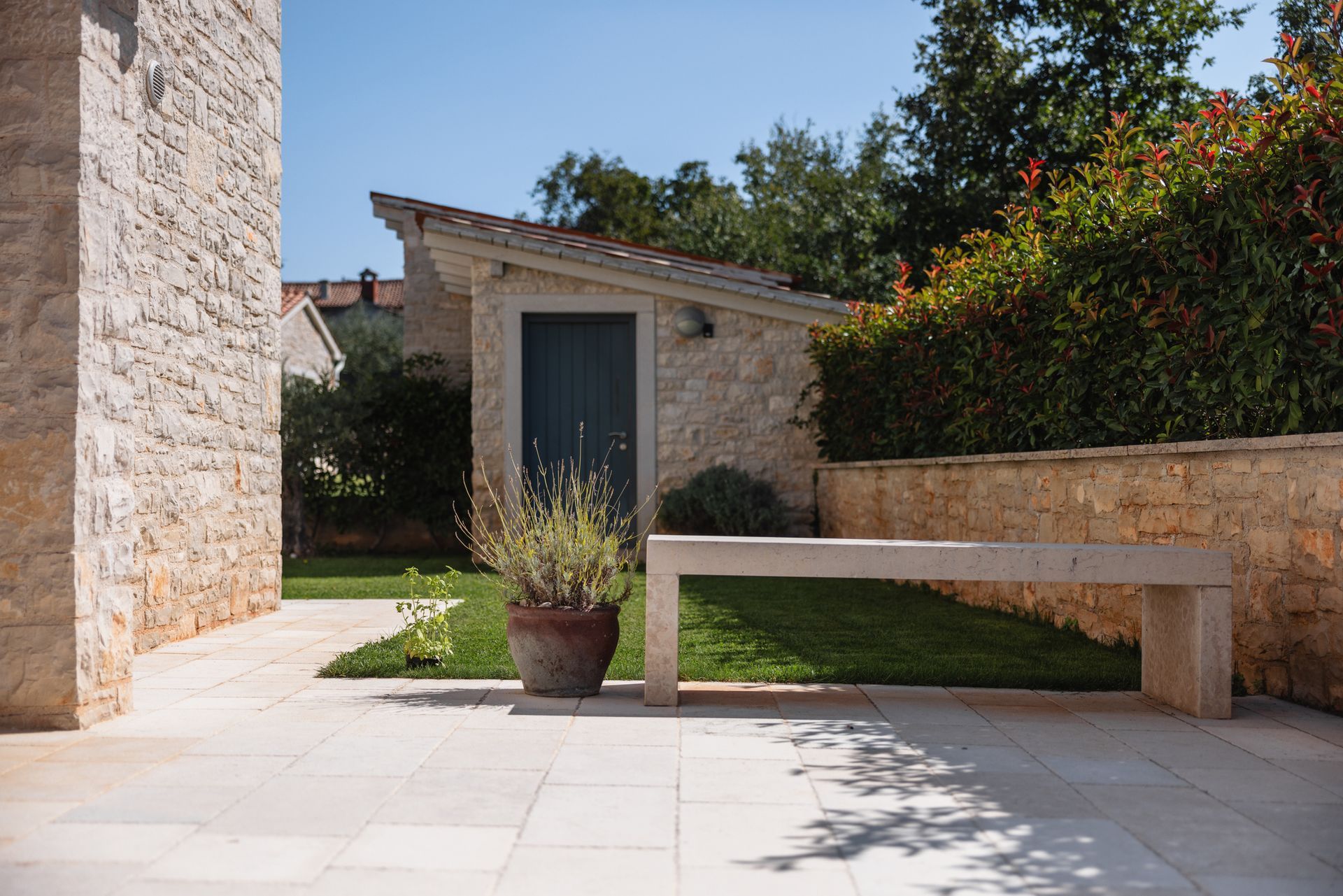 A stone bench is sitting in front of a stone building.